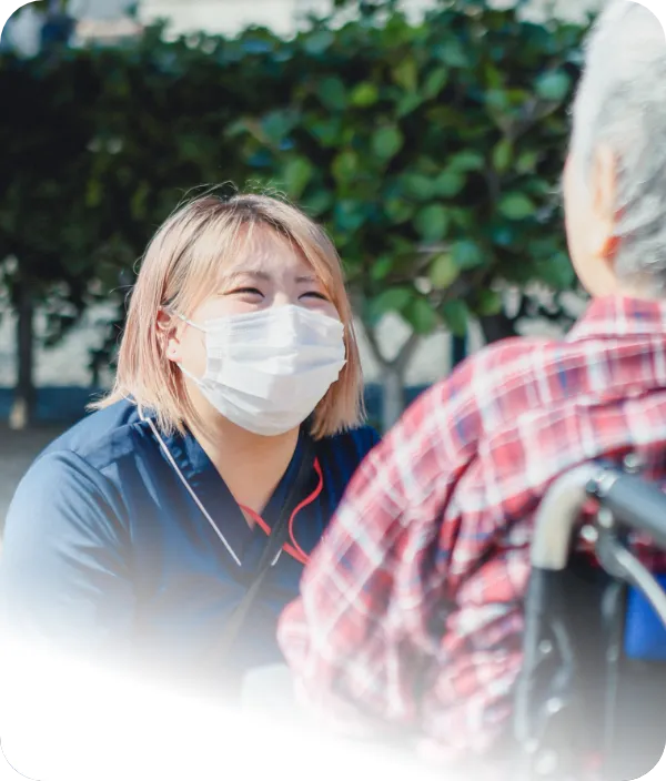 スタッフと利用者様が笑顔で交流する様子 | 株式会社やすら木